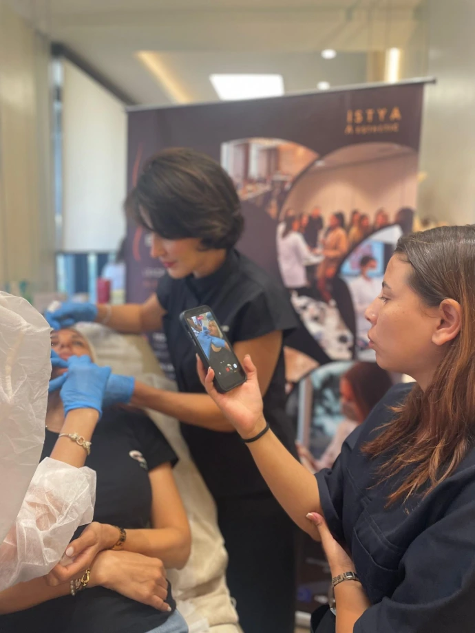 Trainer discussing facial anatomy and injection techniques with medical professionals