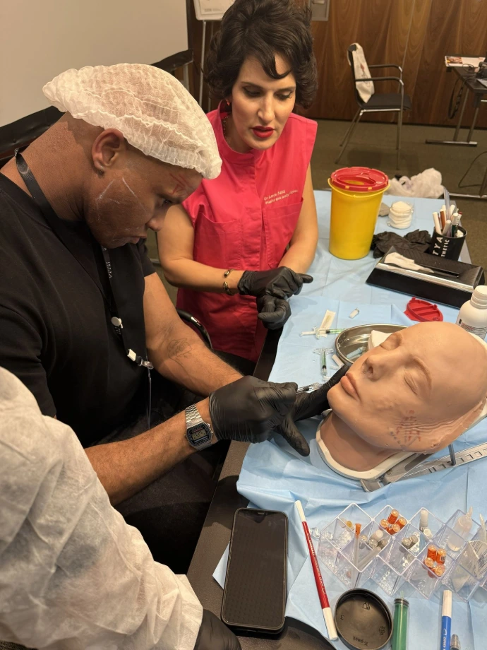 Aesthetic medicine instructor presenting clinical concepts during a medical training workshop