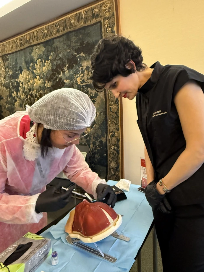 Doctor performing a simulated facial injection as part of aesthetic medicine training